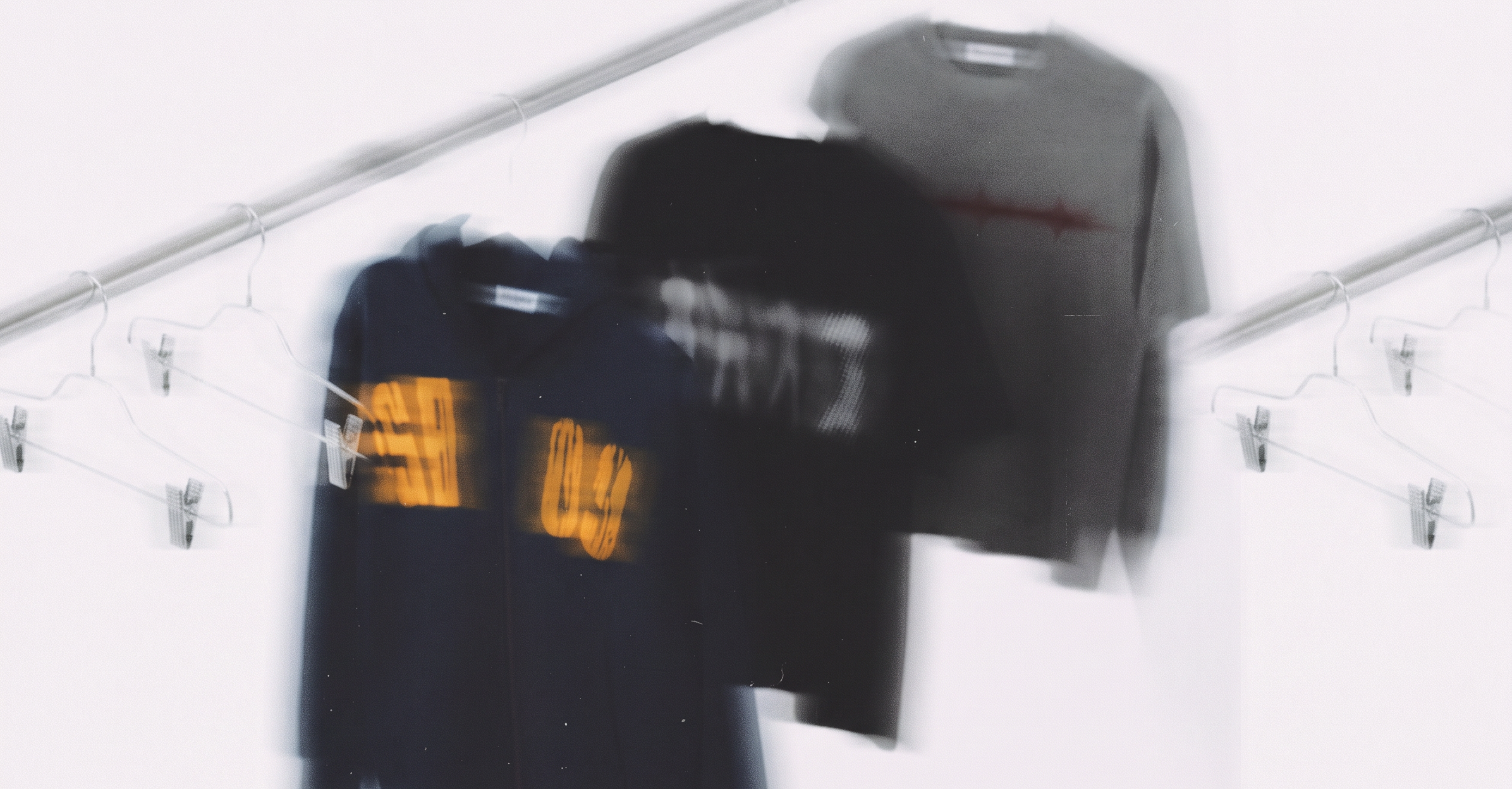 SABLE navy tee, black tee and grey tee hanging on a white clothing rail